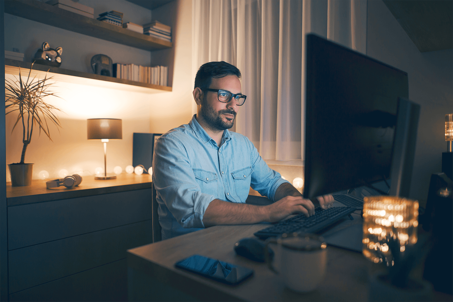 man working late at home in dark office