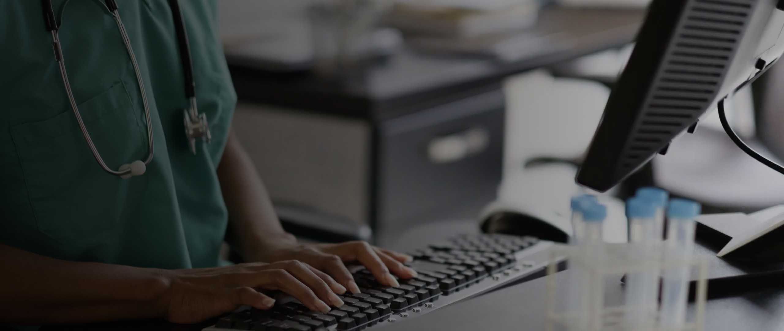 Background image of a healthcare worker at a computer.